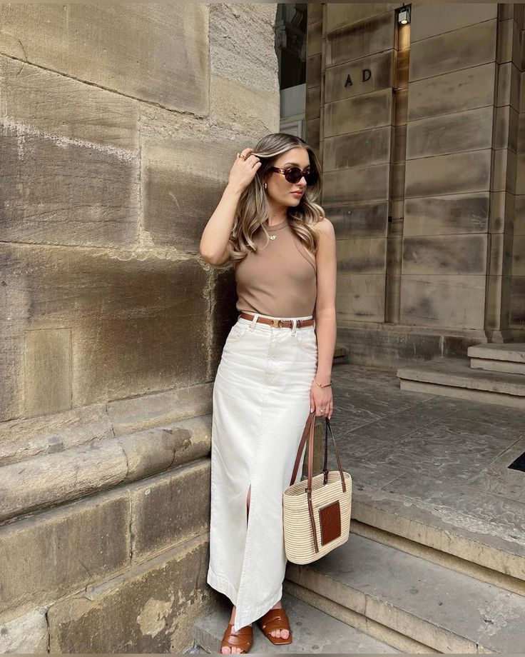 Beige tank top and white skirt with a LOEWE straw bag